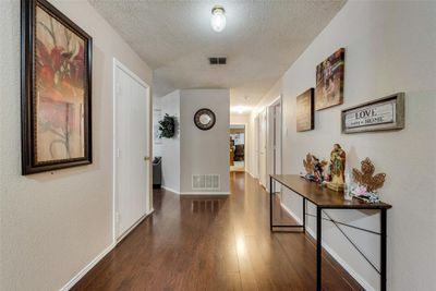 Hall with a textured ceiling and dark hardwood / wood-style floors | Image 3