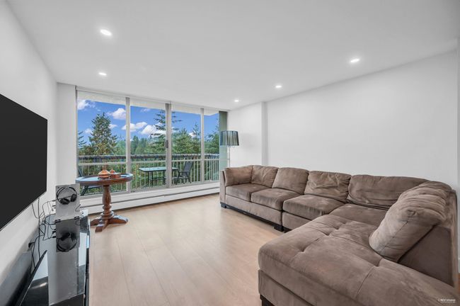 Living room featuring recessed lighting, baseboard heating, a wall of windows, and wood finished floors | Image 15