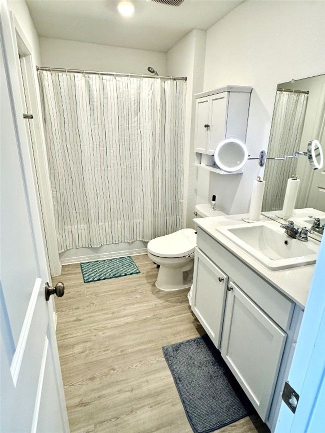 Bathroom with vanity, wood finished floors, and a shower with shower curtain | Image 13