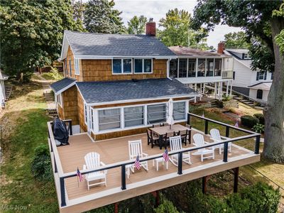 Back of house with a sunroom and a wooden deck | Image 1