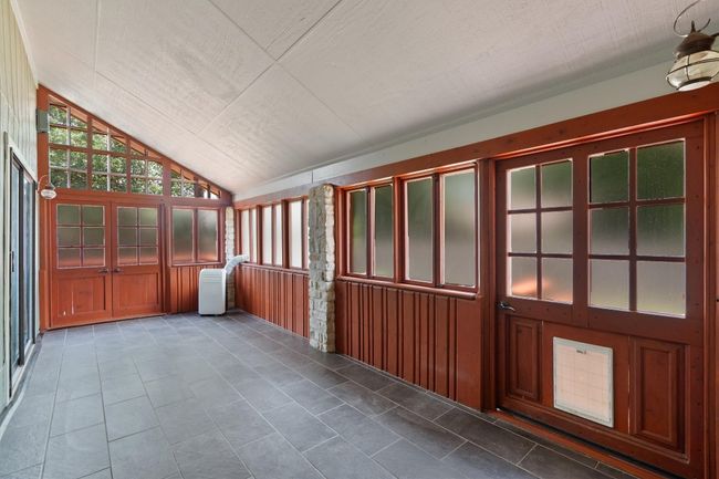 Unfurnished sunroom featuring lofted ceiling | Image 18