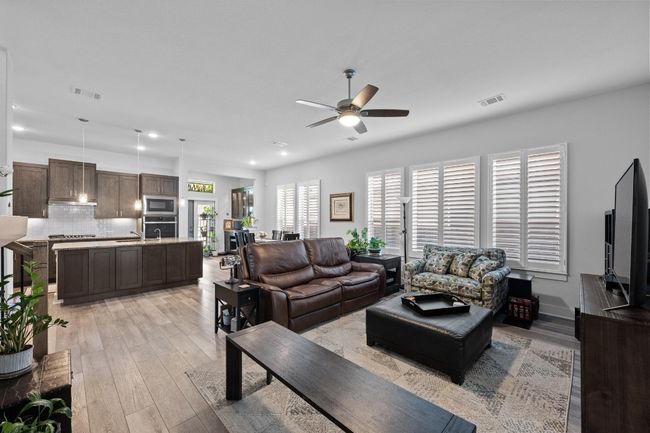The living room has an open floor plan. Plantation shutters throughout the home. | Image 4