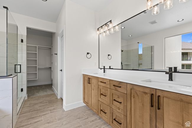 Bathroom featuring a sink, a stall shower, and visible vents | Image 11