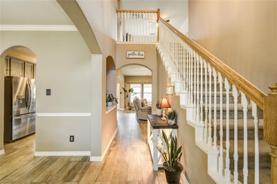 Stunning front entry showcasing a soaring two-story ceiling, with graceful archways leading to the family room ahead, the kitchen to the left, and stairs ascending to the spacious second-story game room. | Image 3