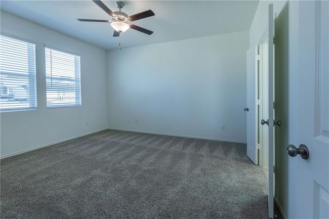 Unfurnished room featuring dark carpet and ceiling fan | Image 28