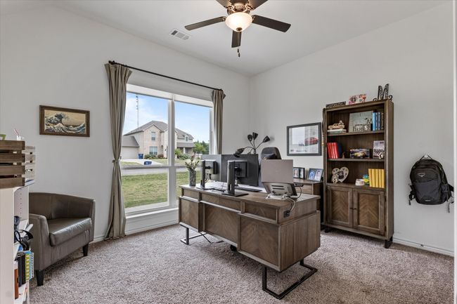 Office space featuring ceiling fan, baseboards, visible vents, and light colored carpet | Image 33