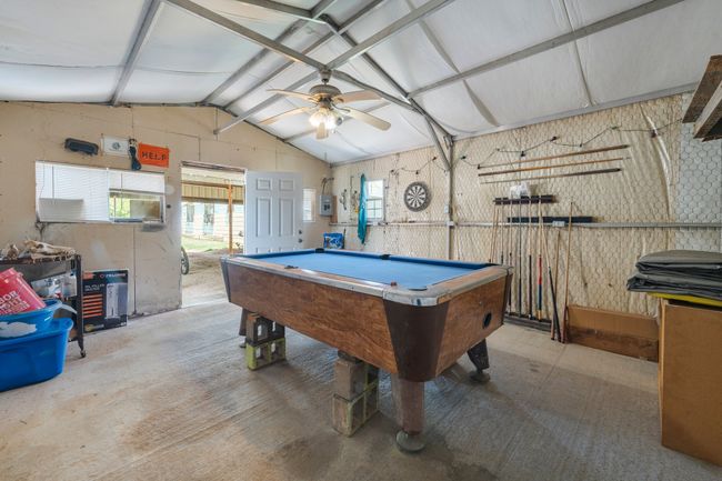 Game room with ceiling fan, billiards, vaulted ceiling with beams, and electric panel | Image 24