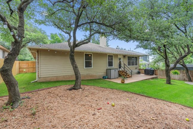 Rear view of house with a patio area, a fenced backyard, a chimney, and entry steps | Image 36