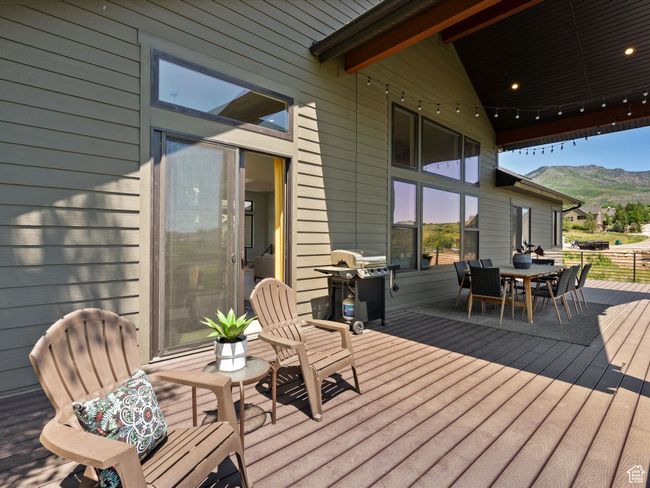 Wooden terrace featuring area for grilling, outdoor dining area, and a mountain view | Image 51