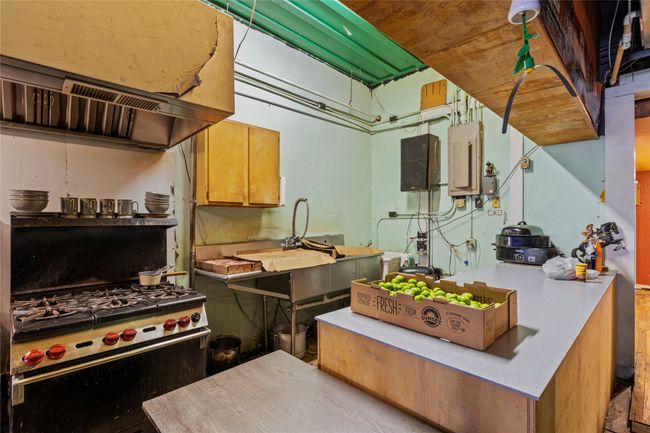 Kitchen with electric panel, custom range hood, and gas stove | Image 16