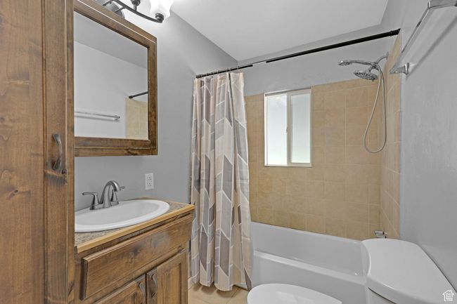 Full bath with toilet, vanity, shower / tub combo with curtain, and tile patterned floors | Image 16