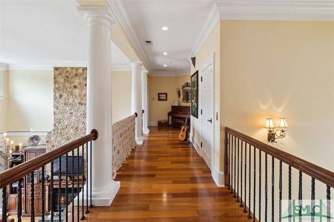 The hallway to the secondary bedrooms is open on the right to the foyer and on the left to the family room. | Image 31