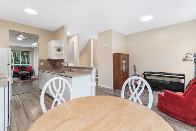 Dining room featuring light wood finished floors, baseboards, and ceiling fan | Image 16