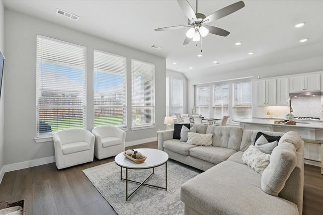 Living room featuring healthy amount of natural light, ceiling fan, wood finished floors, and recessed lighting | Image 7