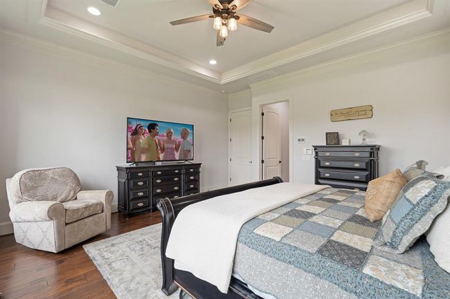 The tray ceiling adds a formal flair, and boasts recessed lighting, as well as a 5-blade ceiling fan. With the room being so grand in size, the space can easily accommodate additional furniture like a dresser, small desk, or cozy seating. | Image 27