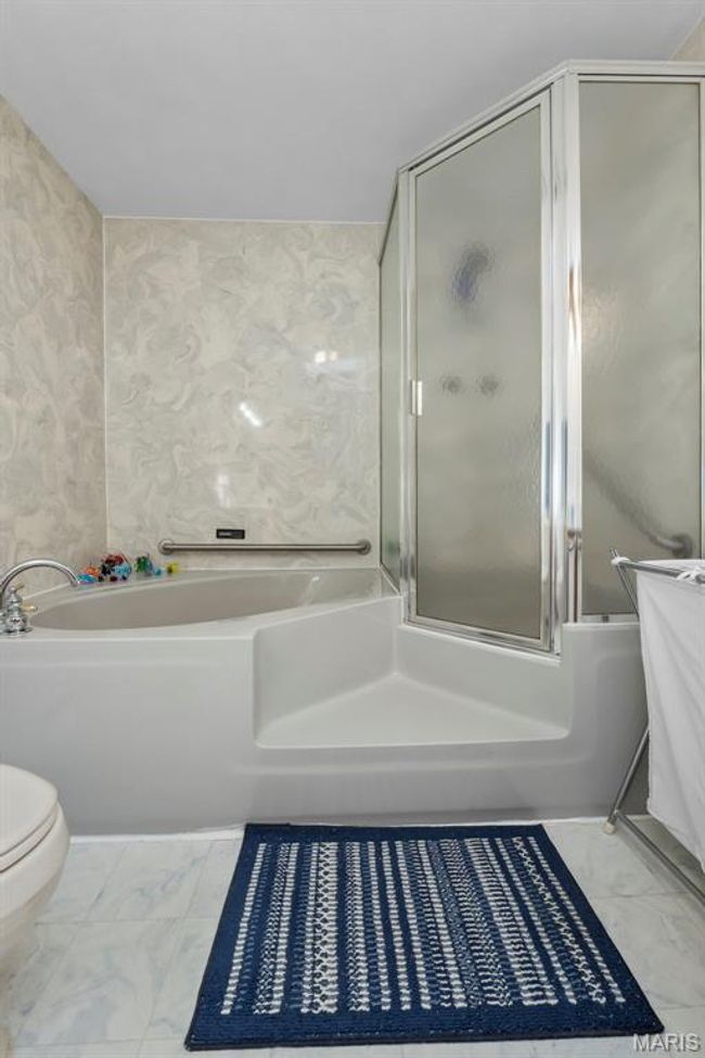 Bathroom with a bath, marble finish floors, and a shower with door | Image 73