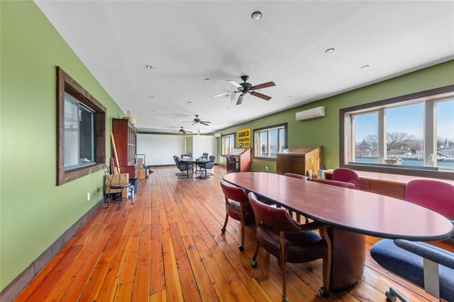 Dining room with a water view, a wall mounted AC, and light wood-type flooring | Image 17