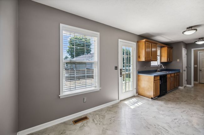 The kitchen and dining area are bathed in natural light, thanks to an abundance of windows that create an airy, open atmosphere! There's also a storm door leading to the deck outside! 2095 Bolden Drive, Murfreesboro, TN 37127 | Image 12