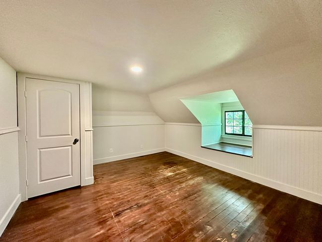 Bonus room featuring wood-type flooring, vaulted ceiling, and a wainscoted wall | Image 19