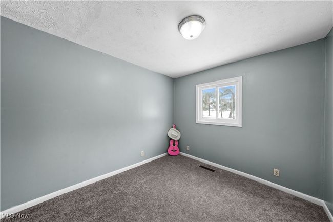 Carpeted bedroom featuring a textured ceiling | Image 14