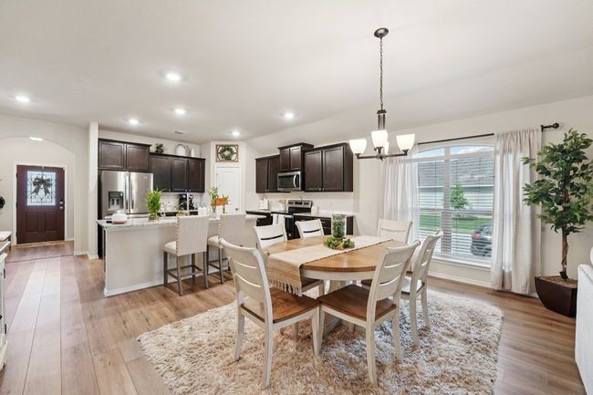 Dining room featuring arched walkways, a chandelier, recessed lighting, and light wood-style flooring | Image 11