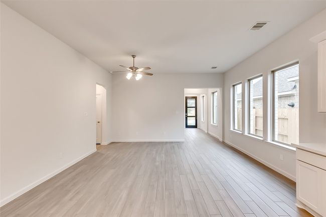 Spare room featuring light wood-style floors, ceiling fan, baseboards, and arched walkways | Image 8
