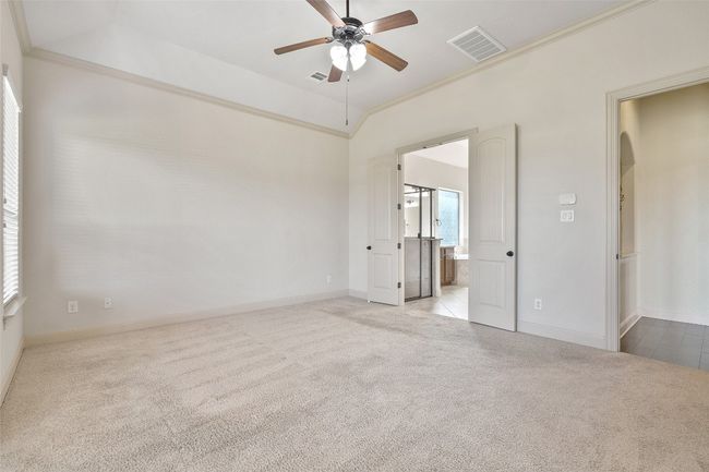 Unfurnished bedroom featuring crown molding, carpet floors, ensuite bathroom, and ceiling fan | Image 27