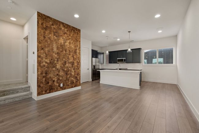 Kitchen featuring stainless steel appliances, a center island with sink, light countertops, baseboards, and dark cabinets | Image 15
