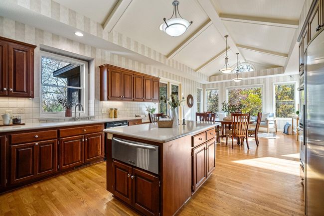 Spacious kitchen with beautifully vaulted ceilings walks out to screened in porch and deck with natural gas grill | Image 12
