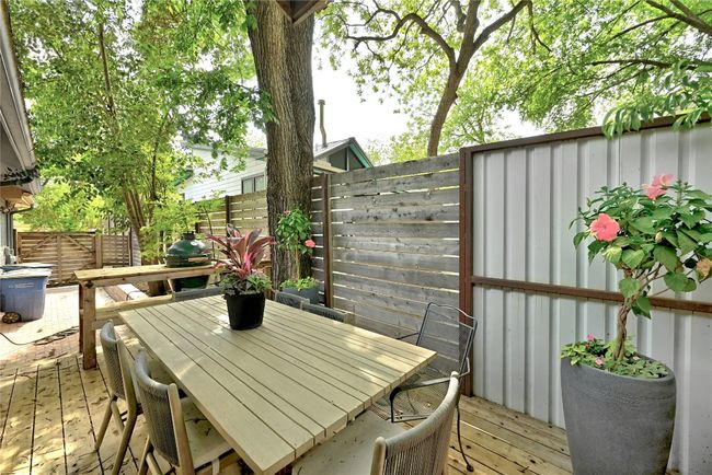 Wooden deck with a fenced backyard and outdoor dining space | Image 14