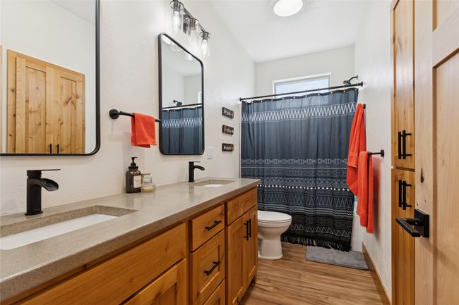 Bathroom with a sink, toilet, double vanity, and wood finished floors | Image 14