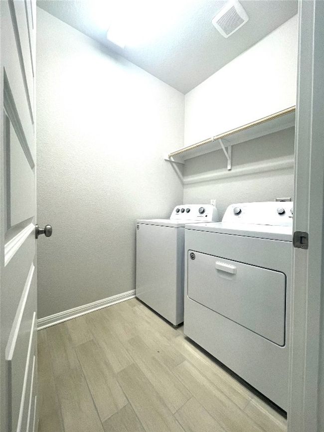 Laundry room with independent washer and dryer and light wood finished floors | Image 20