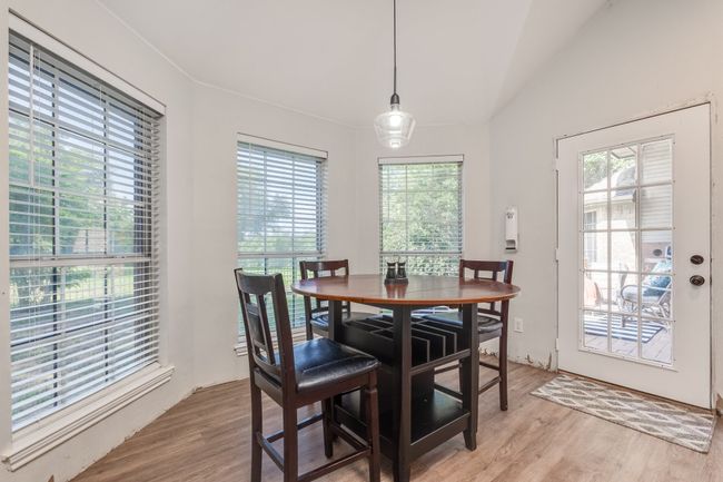 Dining area with healthy amount of natural light, light wood-style floors, and lofted ceiling | Image 23
