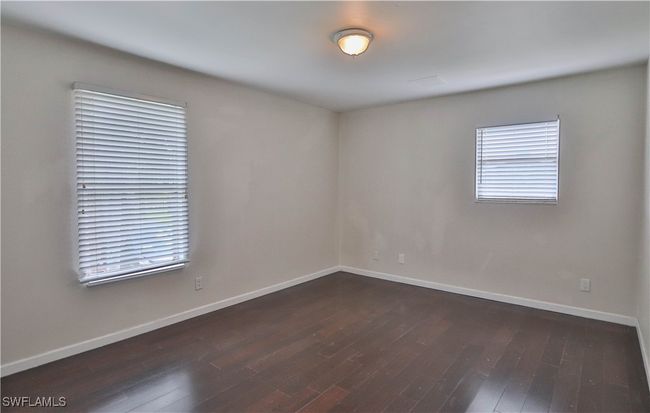 Empty room with dark wood-type flooring and baseboards | Image 25