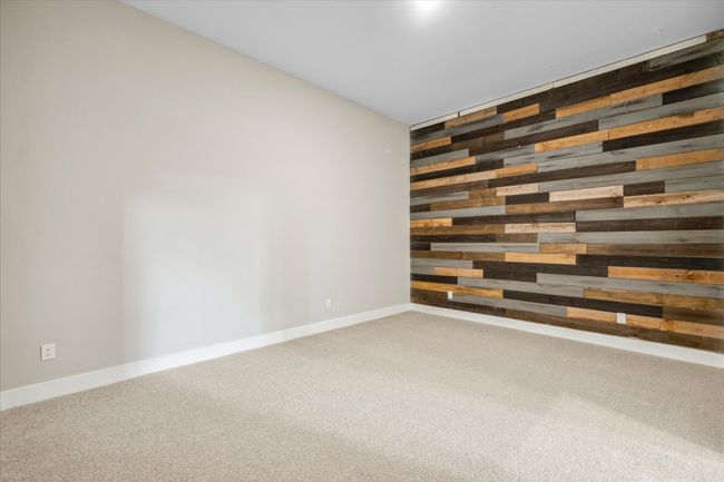 Spare room featuring wood walls, carpet floors, and baseboards | Image 19