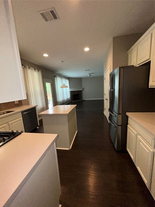 Kitchen featuring a center island, white cabinetry, recessed lighting, fridge, and open floor plan | Image 16