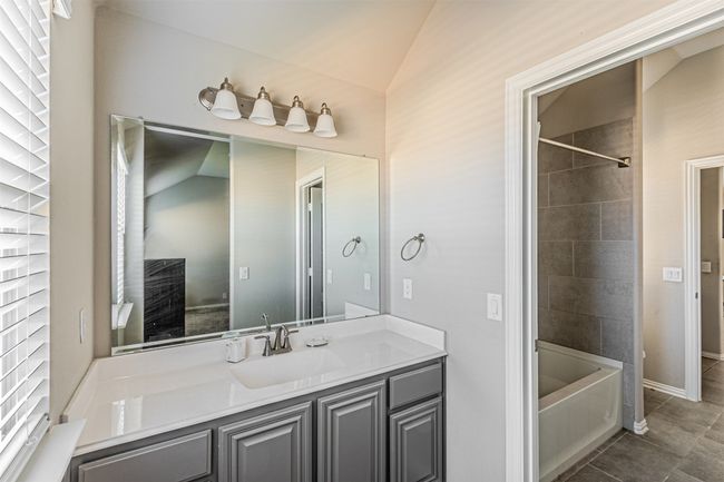 Full bathroom with tile patterned floors, vanity, washtub / shower combination, and baseboards | Image 34