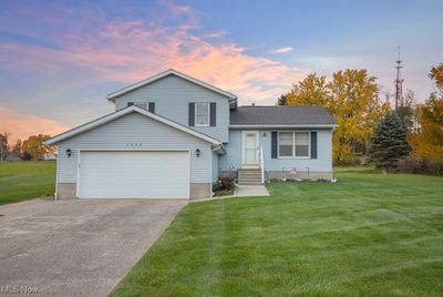 Tri-level home featuring a garage and a lawn | Image 1