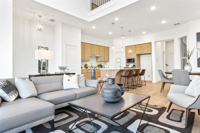 Living room featuring light wood-type flooring, a towering ceiling, and recessed lighting | Image 15