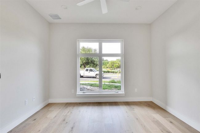 Unfurnished room with plenty of natural light, light wood finished floors, a ceiling fan, and baseboards | Image 13