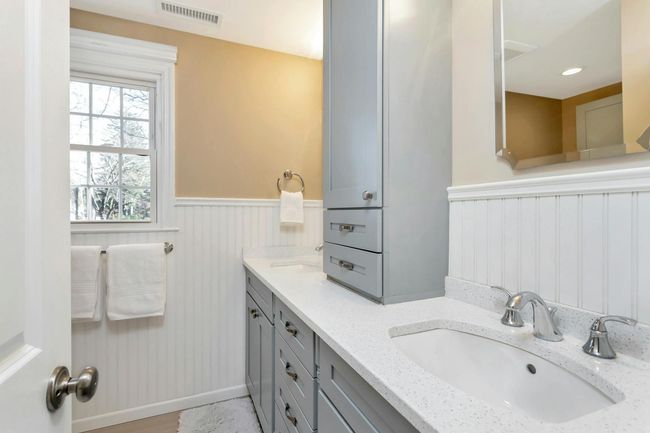 Completely renovated hallway full bath with Silestone countertop and wainscoting. | Image 22