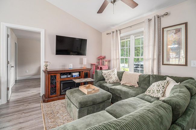 Living room featuring wood finished floors, vaulted ceiling, a ceiling fan, and baseboards | Image 5