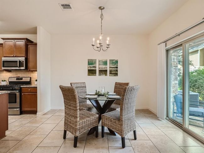 Different unity. Staged. Same floorplan. Dining room featuring a chandelier, light tile patterned floors, and baseboards | Image 5