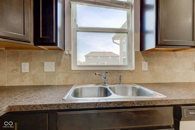 kitchen featuring dark brown cabinets and decorative backsplash | Image 9