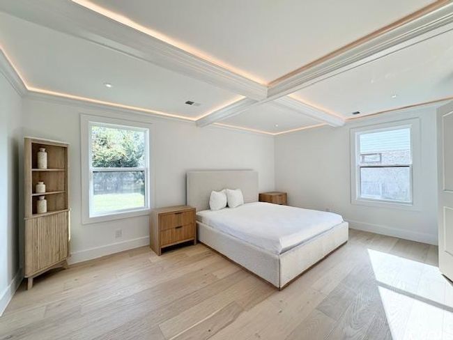 Bedroom with light wood-style floors, beam ceiling, and coffered ceiling | Image 19