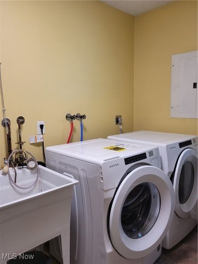 Laundry room featuring electric panel, independent washer and dryer, and sink | Image 3