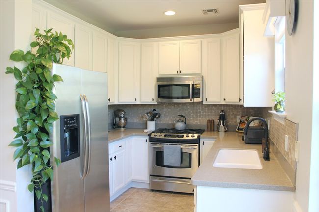 Kitchen featuring a sink, decorative backsplash, light countertops, and stainless steel appliances | Image 9