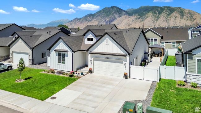 View of front facade featuring board and batten siding, a gate, a garage, driveway, and a mountain view | Image 4