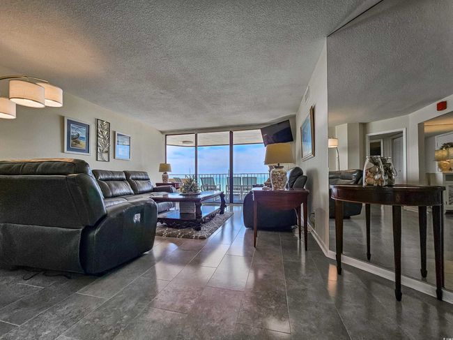 Living room with a wall of windows and a textured ceiling | Image 11