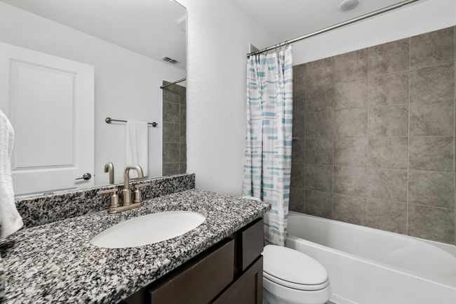 Full bathroom with shower / bath combination with curtain, vanity, and toilet | Image 20